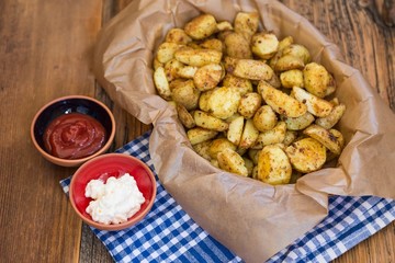 .baked potatoes with ketchup and mayonnaise on wooden background . food concept