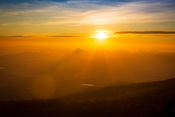 The sun rises on the top of the hill in the morning,Fog in mountain before sunrise in thailand