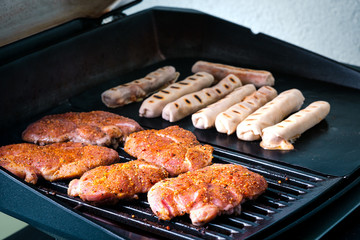 Schweine-Steaks und Pizzaröllchen am Grill