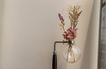 Beautiful dried flowers in a vintage glass vase for decoration at white brick background with empty wall with minimal Style.