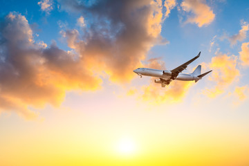 Commercial airplane flying in beautiful sky at sunset,travel concept.