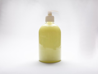 plastic bottle of yellow antiseptic soap with dispenser on a white background