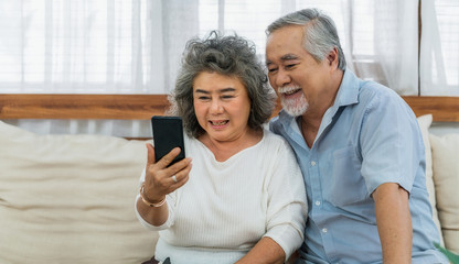 Asian couple Grandparent taking Video call to grandchild or taling selfie with happy feeling by...