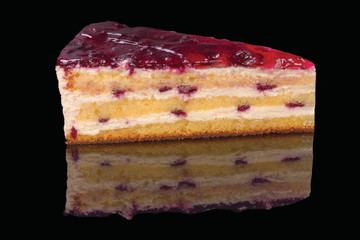 Delicate cake stuffed with natural raspberries and cream coated with raspberry gel and decorated with chocolate gel. Isolated on black background