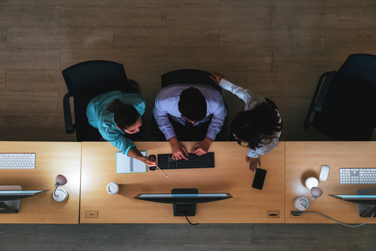 Top view of Three Asian customer care service working hard late in night shift at office,call center department