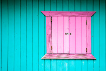 Colorful scenic view of tropical blue painted wall with bright pink window on a typical West Indian...