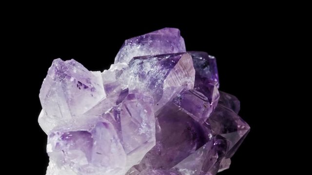 Seamlessly rotating a purple mineral (Amethyst) in front of black background.