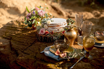 Wedding table setting in rustic style in nature, decoration of glassware, fresh flowers and eucalyptus branches