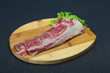 Raw beef bacon over wooden board