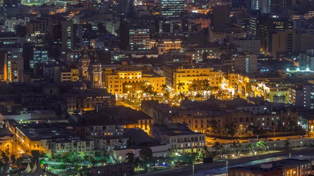 Aerial top view of Lima main square from San Cristobal hill day to night transition timelapse, government palace of Peru and cathedral church. People gathered at Plaza de Armas in the historic center