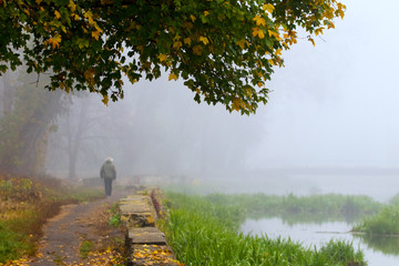 Old city park in autumn, man walking in park