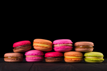 Obraz na płótnie Canvas Stack of french colorful macaroons in row isolated on black background