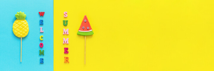 Welcome summer colorful text, pineapple and watermelon lollipops on stick on blue yellow background. Concept vacation or holidays Creative Top view Template Greeting card, postcard