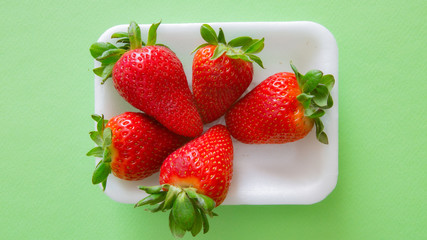 Five strawberry for green background