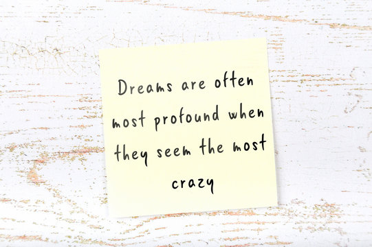 Wise quote on sticky note on wooden wall 