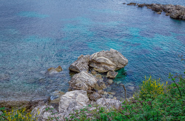 Beautiful landscape with sea bay with turquoise water, rocks and cliffs, green trees and bushes. Corfu Island, Greece. 