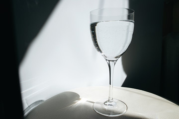 Glass of water on a white background. A glass reflects glare. Transparent glass with wine.