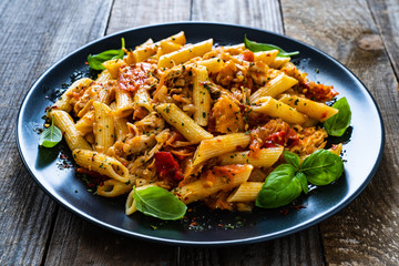 Chicken ragout with penne on wooden table