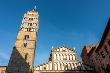 The elegant Romanesque style facade and bell tower of Pistoia Cathedral (Cattedrale di San Zeno), Tuscany, Italy.