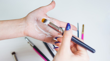 Cleaning and care of makeup brushes, women's hands wash the brush from cosmetics,