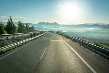 Empty highway landscape with fog and sun shining