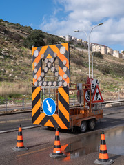 Road servicing after heavy rains. Passage is blocked by red road cones.