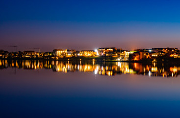 Fototapeta na wymiar A beutiful water reflection of the city of Skanderborg in Denmark by night at a lake