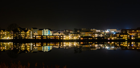 Fototapeta na wymiar A beutiful water reflection of the city of Skanderborg in Denmark by night at a lake