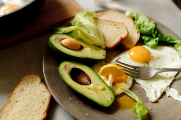 Healthy breakfast: scrambled eggs, toast, avocado, lettuce, rosemary
