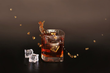 whiskey splash with ice isolated on black background