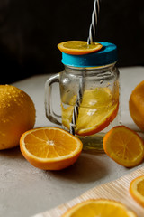 Orange juice and whole oranges on a gray background

