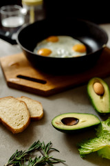 Healthy breakfast: scrambled eggs, toast, avocado, lettuce, rosemary
