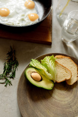 Healthy breakfast: scrambled eggs, toast, avocado, lettuce, rosemary
