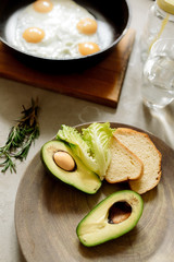 Healthy breakfast: scrambled eggs, toast, avocado, lettuce, rosemary

