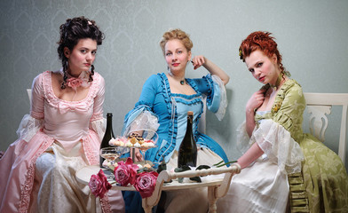 Three beautiful ladies in lavish dresses at a party in a historical setting