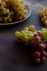 Red and white grapes on a dark capital
