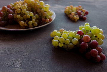 Red and white grapes on a dark capital