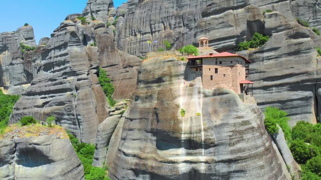 Greece. The historical region of Thessaly. Rocks of Meteora. Complex of Orthodox monasteries. A popular place of pilgrimage and tourism. Drone. Aerial view. The camera moves up