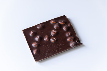 A bar of milk chocolate with hazelnuts on a white background