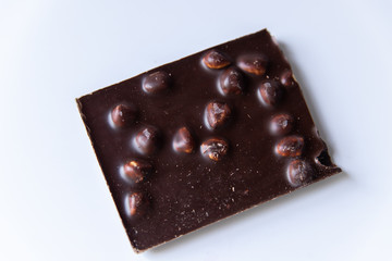 A bar of milk chocolate with hazelnuts on a white background