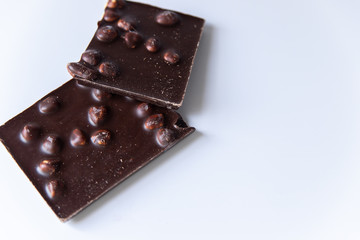A bar of milk chocolate with hazelnuts on a white background