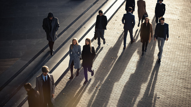 High Angle Shot of Office Managers and Business People Commuting to Work in the Morning or from Office on a Sunny Day on Foot. Pedestrians are Dressed Smartly. Successful People Holding Smartphones.