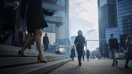 Office Managers and Business People Commute to Work in the Morning or from Office on a Sunny Day on Foot. Pedestrians are Dressed Smartly. Successful People Holding Smartphones. Cloudy Day in Downtown