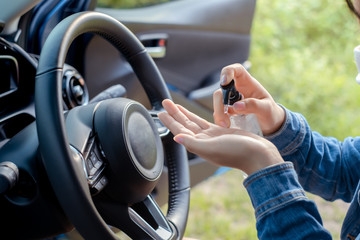 Close up woman wearing mask protective applying hand sanitizer gel alcohol cleaning eliminate protection germs, virus and bacteria in car while driving transportation coronavirus,covid-19 health care.