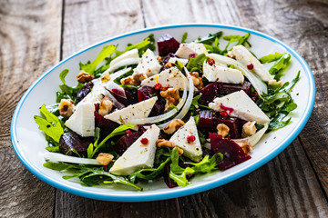  Beetroot salad with feta cheese on wooden table
