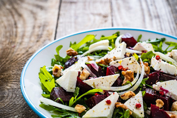  Beetroot salad with feta cheese on wooden table
