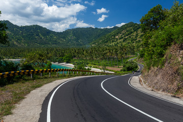 Scenic asphalt road along the coastline of the island of Lombok in Indonesia