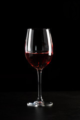 A glass of red wine in dark background