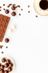 Candy background with chocolate and coffee on white desk top view frame. Cafe concept. Copy space