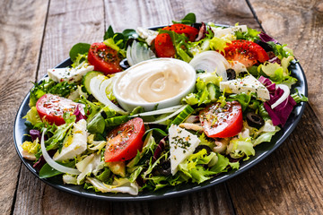 Fresh salad - blue cheese and vegetables on wooden table
